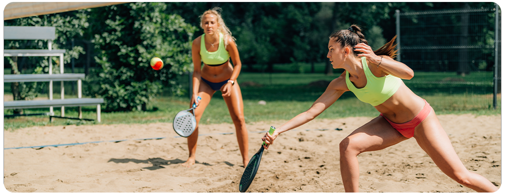 Foto de duas mulheres jogando beach tennis
