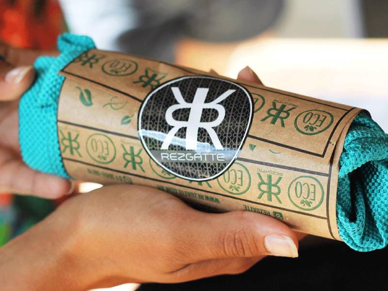 Foto de um tecido enrolado com um papel com a logo da Rezgatte